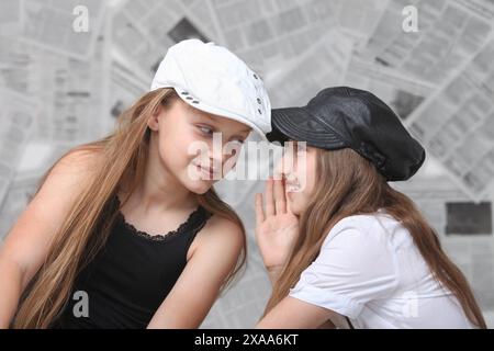 deux jolies filles preteen stylées bavardant sur fond avec des journaux Banque D'Images