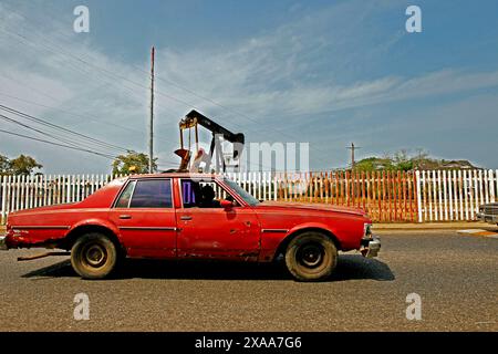 Lac Maracaibo, Venezuela. 18-03-2015. Une vieille voiture colective passe devant une pompe à huile dans le champ gazier de pdvsa. Photo par : Jose Bula. Banque D'Images