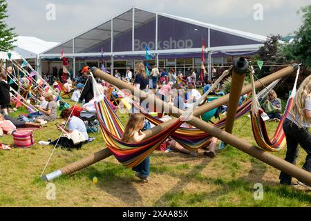 Enfants jouant sur des hamacs personnes dans des transats de jardin devant Book Shop Marquis Hay Book Festival Hay-on-Wye Wales UK Grande-Bretagne KATHY DEWITT Banque D'Images