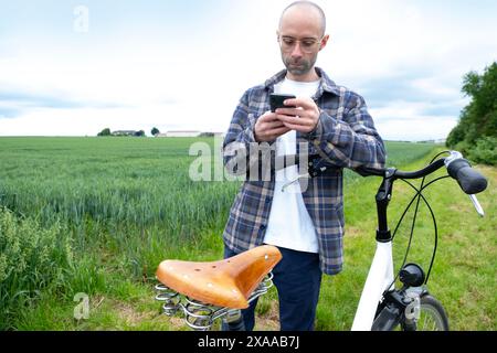 voyage tranquille du jeune homme cycliste à travers des champs verdoyants mélange harmonieux de transport éco-responsable et de nature sereine Banque D'Images