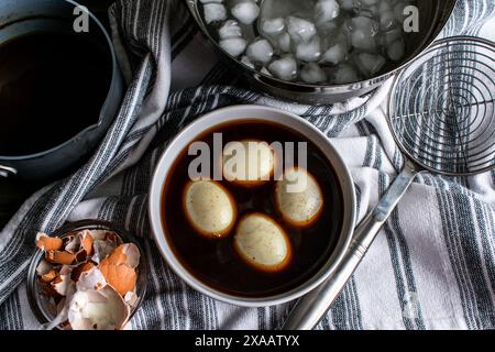 Oeufs durs dans une marinade de sauce soja : préparation d'oeufs de ramen par marination oeufs durs dans un mélange de sauce soja épicée Banque D'Images