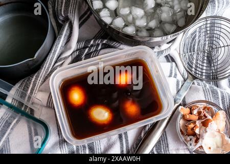 Oeufs durs dans une marinade de sauce soja : préparation d'oeufs de ramen par marination oeufs durs dans un mélange de sauce soja épicée Banque D'Images