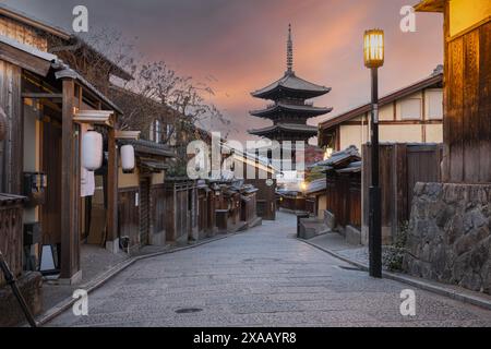 Une rue étroite bordée de vieux bâtiments menant à la pagode Hokan-ji Gojunoto regardant au loin contre le ciel du lever du soleil, Kyoto Banque D'Images