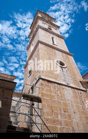 Église de Jérôme de Stridon Beffroi, Pucisca, île de Brac, Croatie 22 mai 2024. De nombreux bâtiments sont construits en pierre blanche et la ville abrite B Banque D'Images