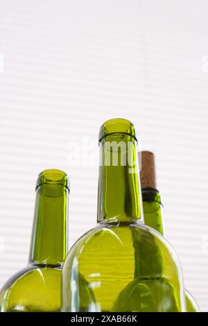composition avec des bouteilles vertes de vin rouge sur fond clair neutre Banque D'Images