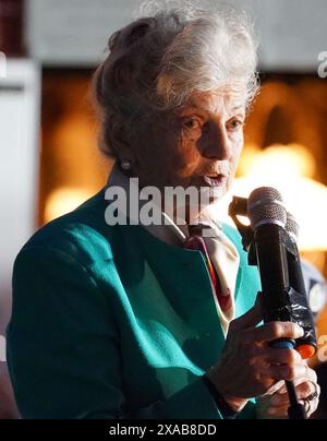 Arlette Gondree, 84 ans, s'exprimant avant de porter un toast au champagne aux vétérans du jour J à 2316 dans la soirée, marquant le moment exact, il y a 80 ans, où les troupes britanniques sont entrées dans le café de sa famille à Benouville, en Normandie, en France, faisant d'eux la première famille à être libérée du contrôle allemand. Date de la photo : mercredi 5 juin 2024. Banque D'Images