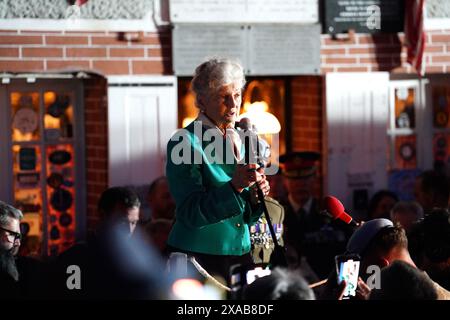 Arlette Gondree, 84 ans, s'exprimant avant de porter un toast au champagne aux vétérans du jour J à 2316 dans la soirée, marquant le moment exact, il y a 80 ans, où les troupes britanniques sont entrées dans le café de sa famille à Benouville, en Normandie, en France, faisant d'eux la première famille à être libérée du contrôle allemand. Date de la photo : mercredi 5 juin 2024. Banque D'Images