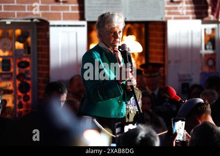 Arlette Gondree, 84 ans, s'exprimant avant de porter un toast au champagne aux vétérans du jour J à 2316 dans la soirée, marquant le moment exact, il y a 80 ans, où les troupes britanniques sont entrées dans le café de sa famille à Benouville, en Normandie, en France, faisant d'eux la première famille à être libérée du contrôle allemand. Date de la photo : mercredi 5 juin 2024. Banque D'Images