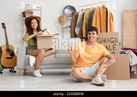 Jeune couple dans la chambre de trucs indésirables. Vente de garage Banque D'Images