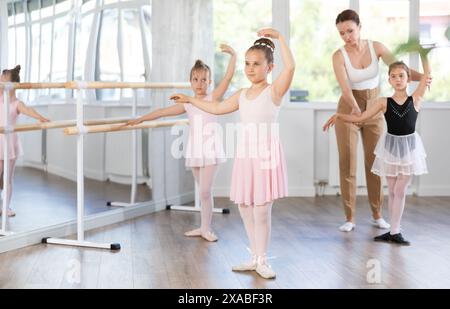 Les petites filles apprennent divers mouvements de danse et de ballet en studio Banque D'Images