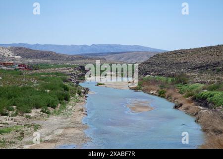 Le Rio Grande serpente à travers les paysages à couper le souffle du parc national de Big Bend, ses rives verdoyantes servant d'oasis au milieu du désert aride Banque D'Images