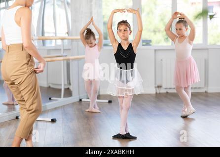 Les petites filles apprennent divers mouvements de danse et de ballet en studio Banque D'Images