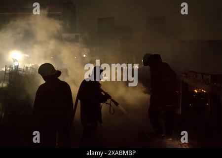 Les pompiers effectuant la phase de refroidissement après un incendie ont incendié des centaines de maisons dans un quartier dense de Jakarta, en Indonésie. Banque D'Images