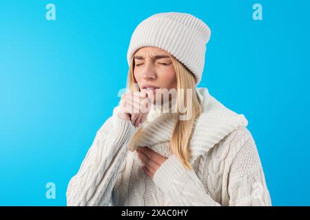 Jeune femme toussant en chandail et chapeau en laine blanche Banque D'Images