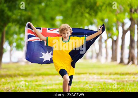 Fans de l'équipe australienne avec drapeau. Enfant supporter australien. Enfant acclamant la victoire de l'équipe de football australien ou de cricket. Drapeau national joyeux petit garçon Banque D'Images