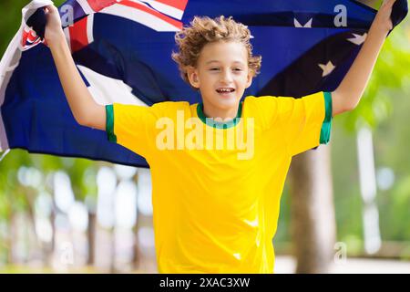 Fans de l'équipe australienne avec drapeau. Enfant supporter australien. Enfant acclamant la victoire de l'équipe de football australien ou de cricket. Drapeau national joyeux petit garçon Banque D'Images