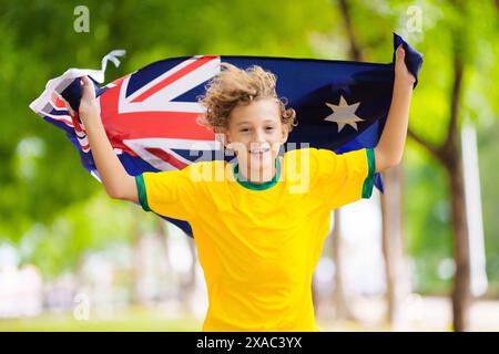 Fans de l'équipe australienne avec drapeau. Enfant supporter australien. Enfant acclamant la victoire de l'équipe de football australien ou de cricket. Drapeau national joyeux petit garçon Banque D'Images