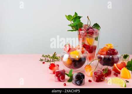 Boissons rafraîchissantes fraîches avec des glaçons avec des baies et des fruits et de la menthe, boisson froide d'été Banque D'Images