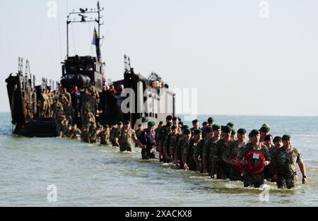 Un débarquement des Royal Marines de 47 Commando à Asnelles avant leur 'yomp' annuel à Port-en-Bessin, en Normandie, France, pour commémorer le 80e anniversaire du débarquement du débarquement. Date de la photo : jeudi 6 juin 2024. Banque D'Images