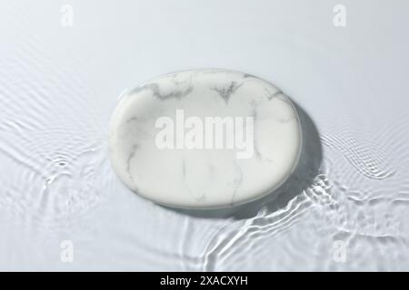 Présentation du produit. Podium en marbre dans l'eau sur fond blanc, vue de dessus Banque D'Images