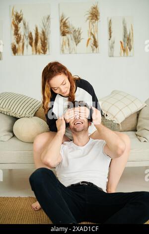 Un homme et une femme assis confortablement dans une chambre confortable, engagés dans une conversation profonde. Banque D'Images