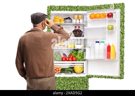 Vue arrière d'un homme âgé regardant un réfrigérateur économe en énergie avec des aliments isolés sur fond blanc Banque D'Images