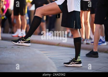 Pieds de coureur ukrainien s'étirant avant la course urbaine. Kiev - 1er juin 2024 Banque D'Images
