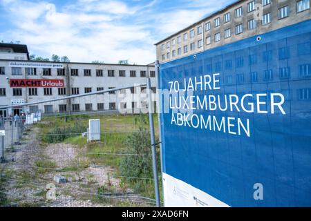 05 juin 2024, Mecklembourg-Poméranie occidentale, Prora : une affiche avec l'inscription '70 ans de l'accord de Luxembourg' est accrochée devant l'entrée du Centre de documentation de Prora sur le terrain de la station balnéaire KdF de Prora dans la municipalité de Binz sur l'île de Rügen. Les visiteurs du Centre de documentation de Prora ont pu se renseigner sur les conséquences de la Shoah depuis le 06.06.2024. Sous le titre "70 ans de l'accord de Luxembourg", neuf grands cubes sont aujourd'hui exposés dans le grand hall de l'ancien bâtiment nazi où se déroule l'exposition du 6 juin à A. Banque D'Images