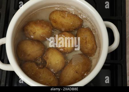 Faire bouillir les jeunes pommes de terre dans une casserole sur la cuisinière, vue de dessus Banque D'Images