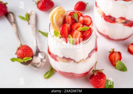 Dessert tiramisu fraise d'été, version fruits de baies du gâteau tiramisu d'été dans des pots en verre avec fraise fraîche, mascarpone et savoyardi Banque D'Images