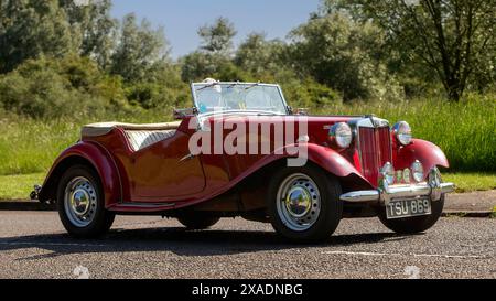 Stony Stratford, Royaume-Uni - 2 juin 2024:1951 rouge MG TD voiture britannique classique conduisant sur une route de campagne britannique Banque D'Images