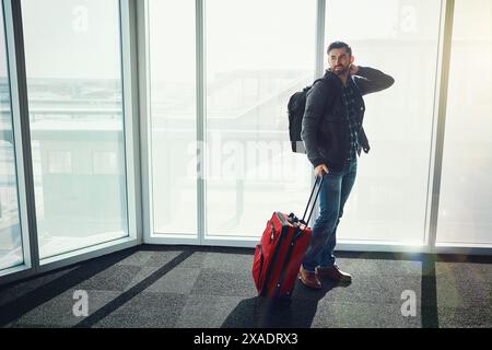 Aéroport, fenêtre et homme avec valise, sourire et voyage d'affaires à New York, sac à dos et réflexion. Entrepreneur, déménagement et bagages pour voyager Banque D'Images