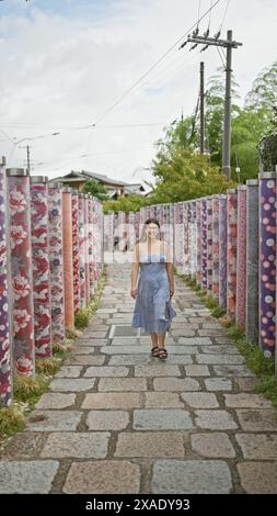 Une femme hispanique joyeuse en lunettes se promène joyeusement dans la célèbre forêt de kimonos de kyoto, son sourire radieux devant la caméra Banque D'Images