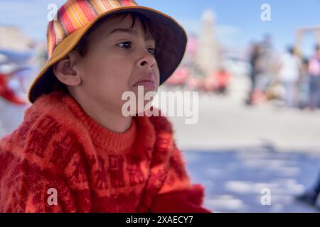 portrait de garçon latin avec casquette rustique et pull dans le profil pleurant, faisant fantaisie. Banque D'Images