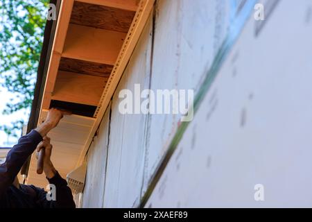 Panneau de soffite en PVC blanc vinyle sous le toit de la planche de bord installé le long de la ligne de toit de la maison. Banque D'Images