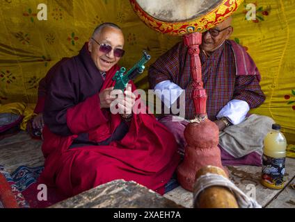 Moine avec un jouet d'arme dans le monastère d'Ura Lhakhang pendant le festival, Bumthang, Ura, Bhoutan Banque D'Images