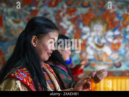 Femmes bhoutanaises dansant pendant Ura Yakchoe dans le temple, Bumthang, Ura, Bhoutan Banque D'Images