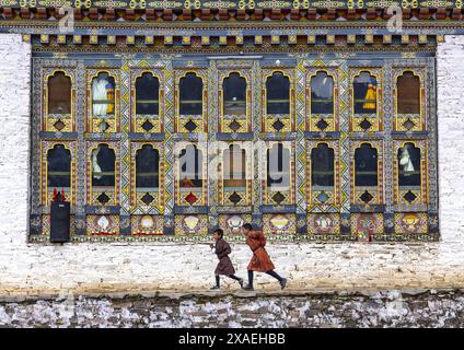 Enfants bhoutanais courant dans le monastère d'Ura Lhakhang, Bumthang, Ura, Bhoutan Banque D'Images