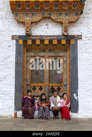 Une famille bhoutanaise est assise devant une porte à Nyenzer Lhakhang, Punakha dzongkhag, Punakha, Bhoutan Banque D'Images