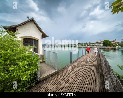 Rapperswil, Suisse - 6 juin 2024 : les gens marchent à travers la plus longue passerelle en bois de Suisse, construite en 2001, une passerelle à travers le lac Zuric Banque D'Images