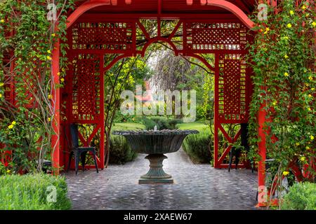 Marrakech, Maroc - 24 mars 2024 : fontaine et gazebo rouge au coeur du jardin Anima à Marrakech Banque D'Images