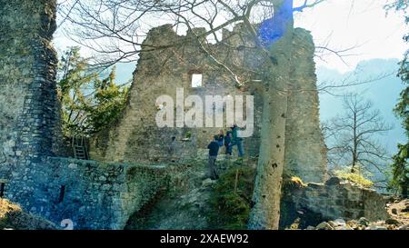 Un groupe de personnes grimpent sur le flanc d'un château. Le château est vieux et a beaucoup de pierre. Les gens regardent le paysage Banque D'Images