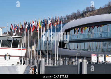 Un grand bâtiment avec de nombreux drapeaux suspendus. Les drapeaux sont de différentes couleurs et tailles. Le bâtiment est entouré d'un quai et d'un bateau Banque D'Images