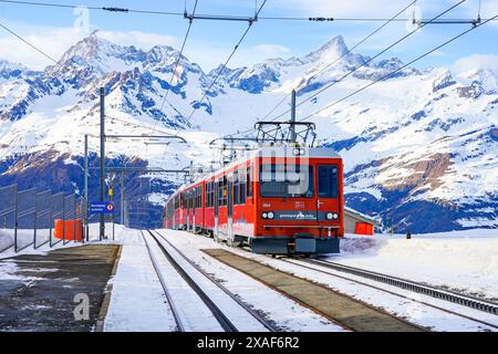 Train à crémaillère du Gornergrat Railway quittant la gare de Rotenboden entourée de montagnes enneigées au-dessus de Zermatt dans les Alpes suisses en W. Banque D'Images