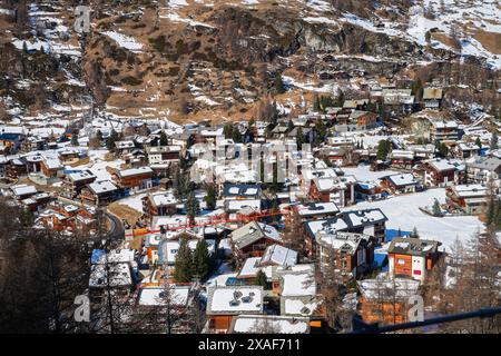 Toits enneigés de Zermatt dans les Alpes suisses en hiver - paysage idyllique avec des chalets en bois dans une célèbre station de ski dominée par le Cervin Banque D'Images