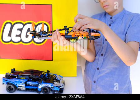 enfant, garçon de 10 ans assemble un avion orange à partir de pièces, constructeur de jouets éducatifs, développement de concept de motricité fine, patie de formation Banque D'Images