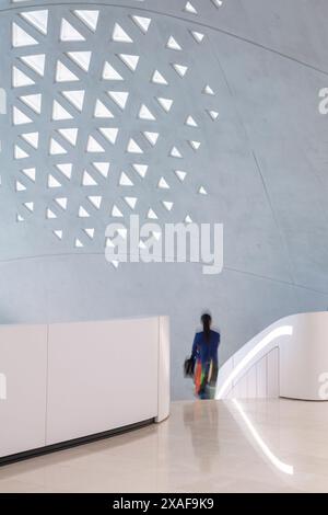 Quelqu'un descend vers le hall d'entrée principal. Siège social de BEEAH, Sharjah, Émirats arabes Unis. Architecte : Zaha Hadid Architects, 2022. Banque D'Images