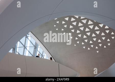 Un groupe de personnes encadrées par l'une des nombreuses courbes fluides présentes dans le bâtiment. Siège social de BEEAH, Sharjah, Émirats arabes Unis. Architecte : Zaha H. Banque D'Images