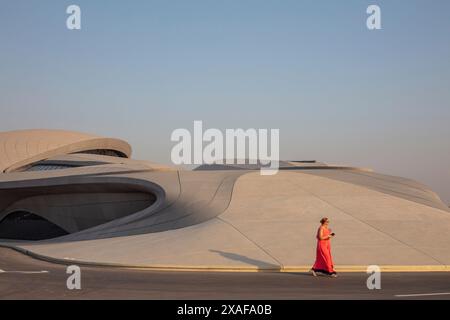 Quelqu'un qui marchait a passé le bout du bâtiment avec un peu de soleil projetant une ombre. Siège social de BEEAH, Sharjah, Émirats arabes Unis. Architecte : Zaha Banque D'Images