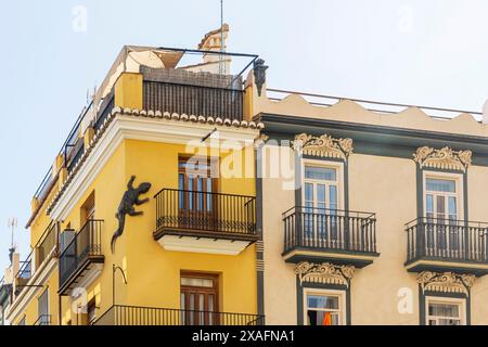 Valencia, Espagne - 20 avril 2024. Bas-relief d'un lézard sur une vieille maison jaune dans la vieille ville. Banque D'Images